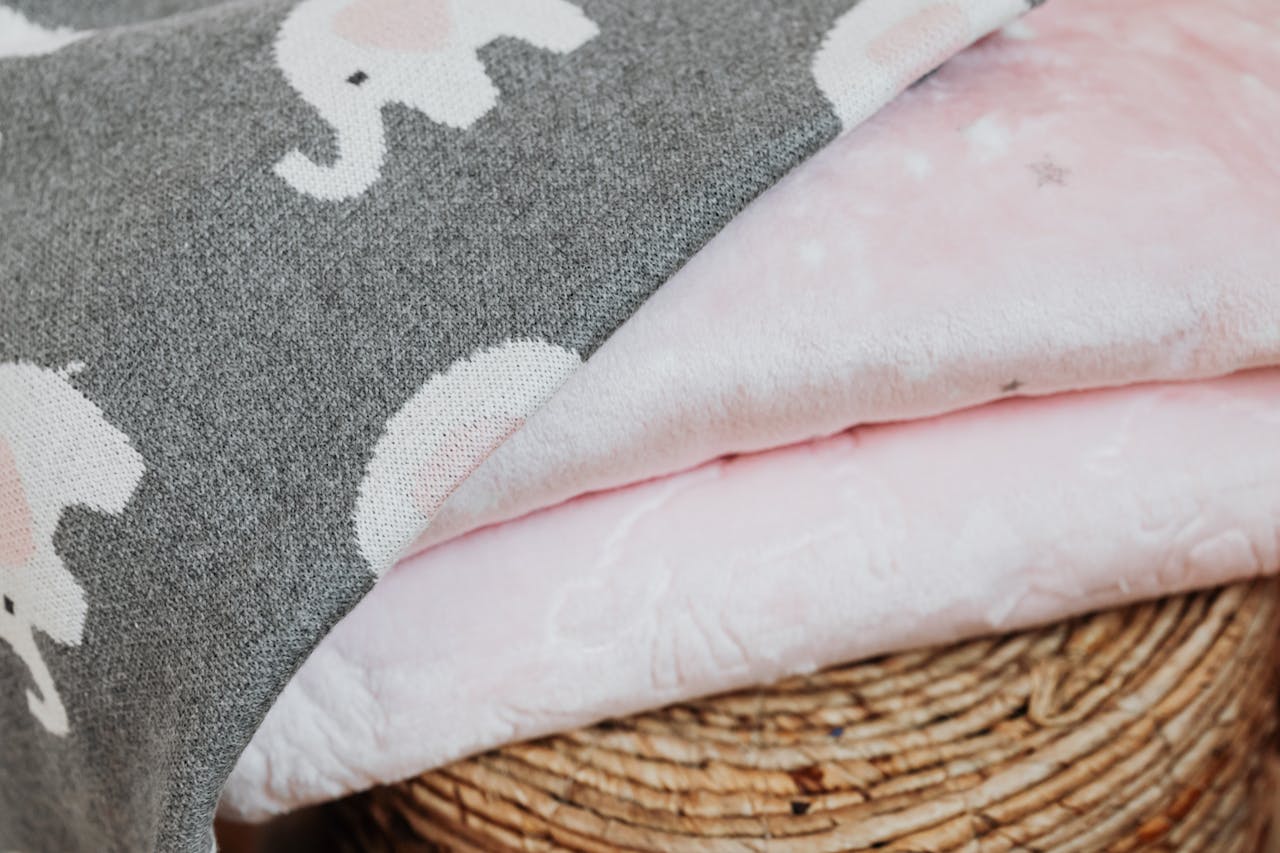 about-01 Close-up of elephant patterned blankets showcasing textured fabric and pastel colors.